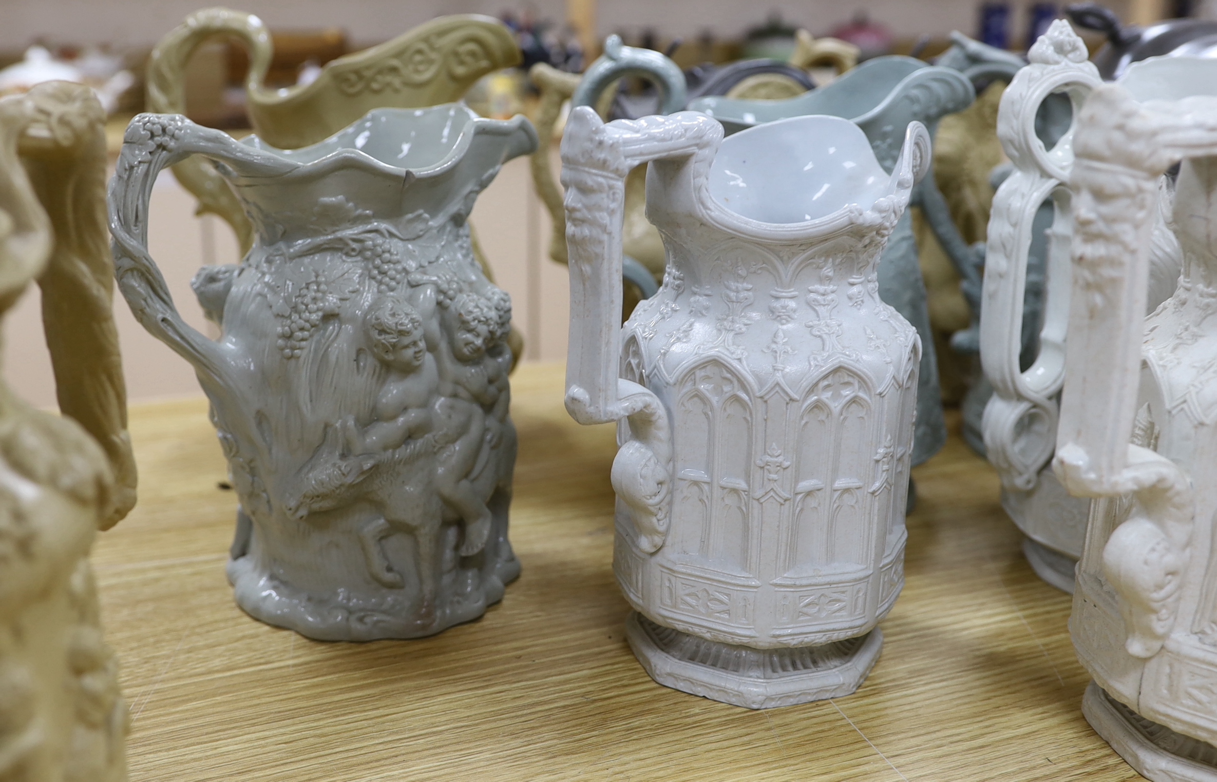 A collection of Victorian Charles Meigh and TJ & JM Mayers stoneware jugs, including Gothic relief designs, some with pewter lids, the largest 23cm high